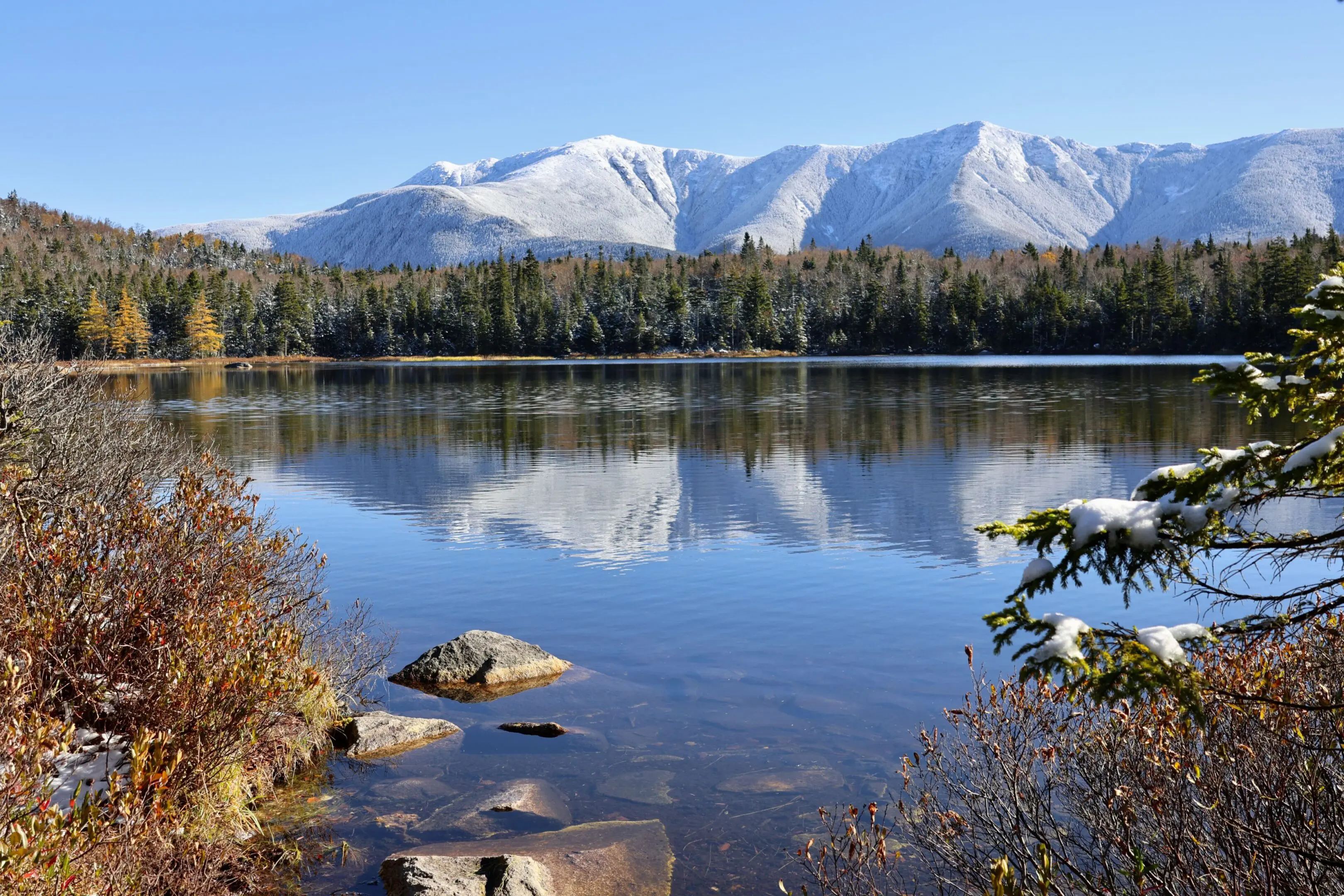 A lake with snow capped mountains in the background.