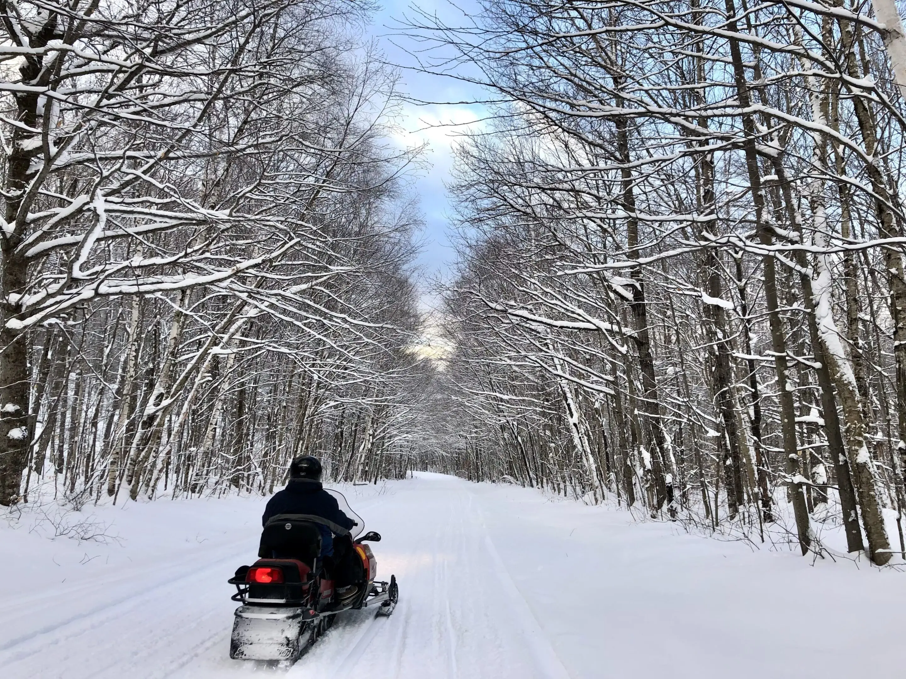 A person on a snowmobile traveling down the road.