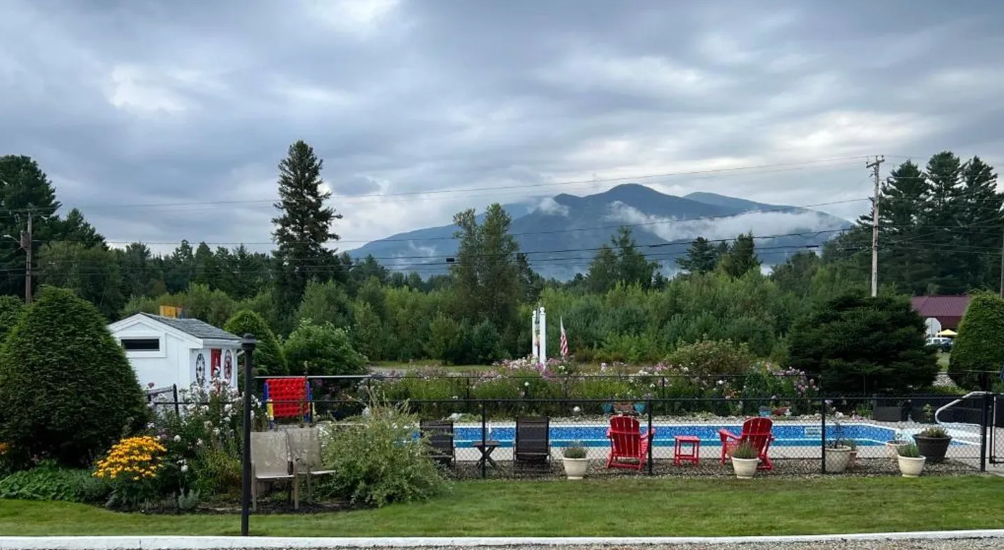 A view of a pool and mountains from the lawn.