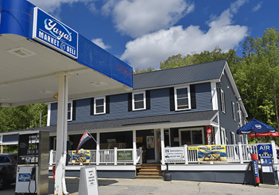 A gas station with blue siding and white trim.