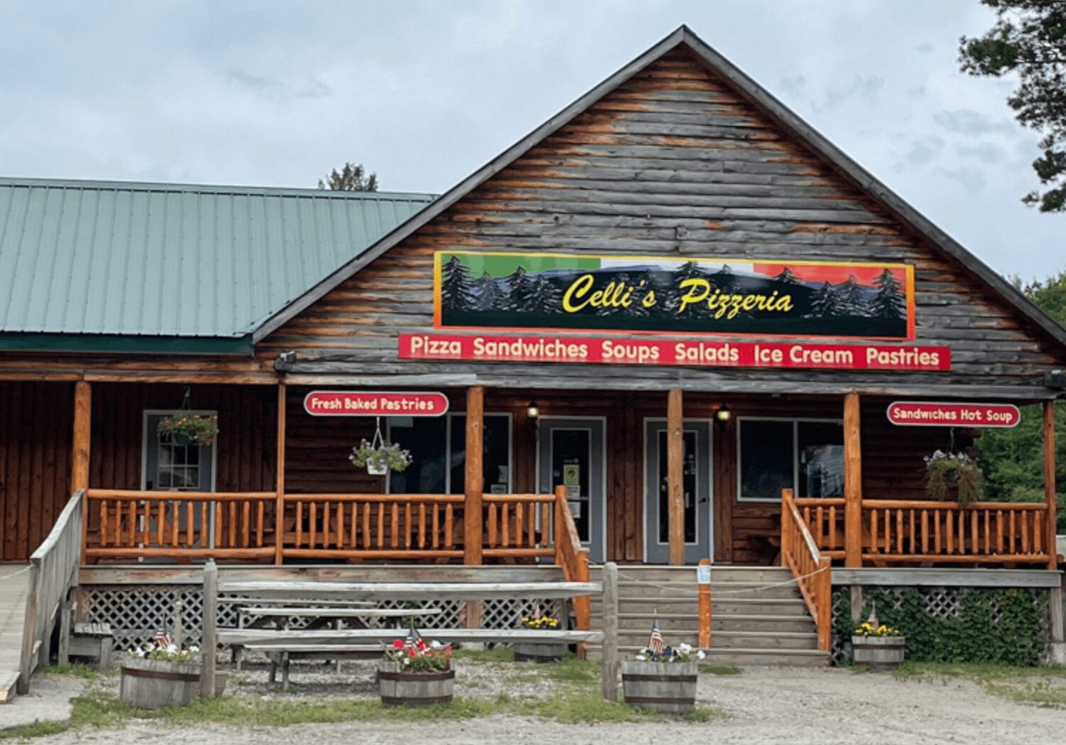 A restaurant with wooden siding and green roof.