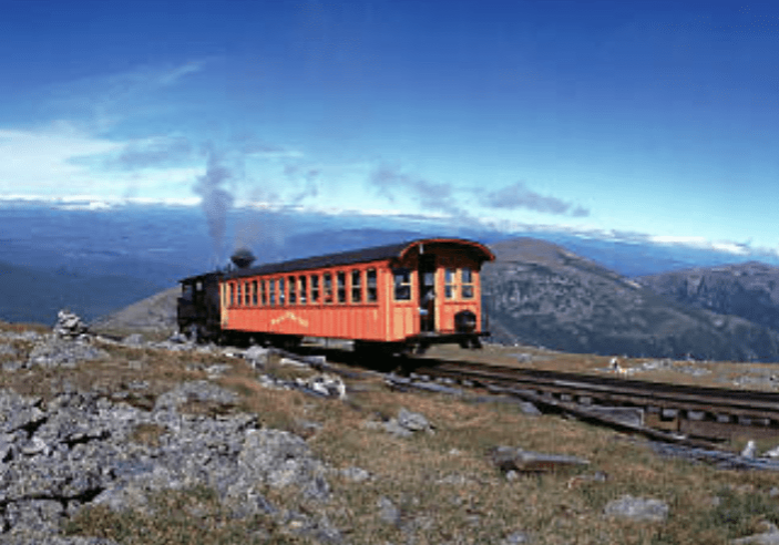 A train traveling on tracks through the mountains.