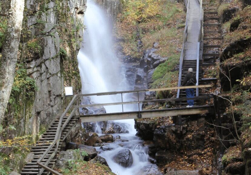 A person standing on stairs near a waterfall.